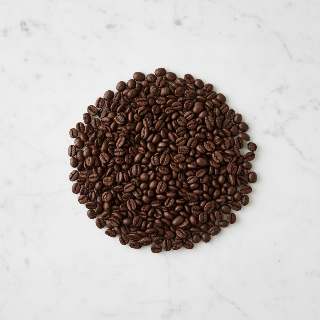 Compact dark roast coffee beans on marble